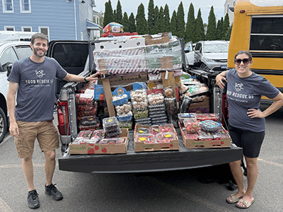 Food Rescue US volunteers next to trunk full of food